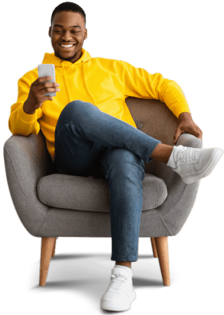 man sitting on chair smiling and pressing phone
