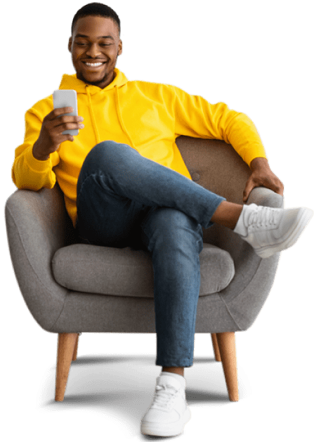 man sitting on chair smiling and pressing phone